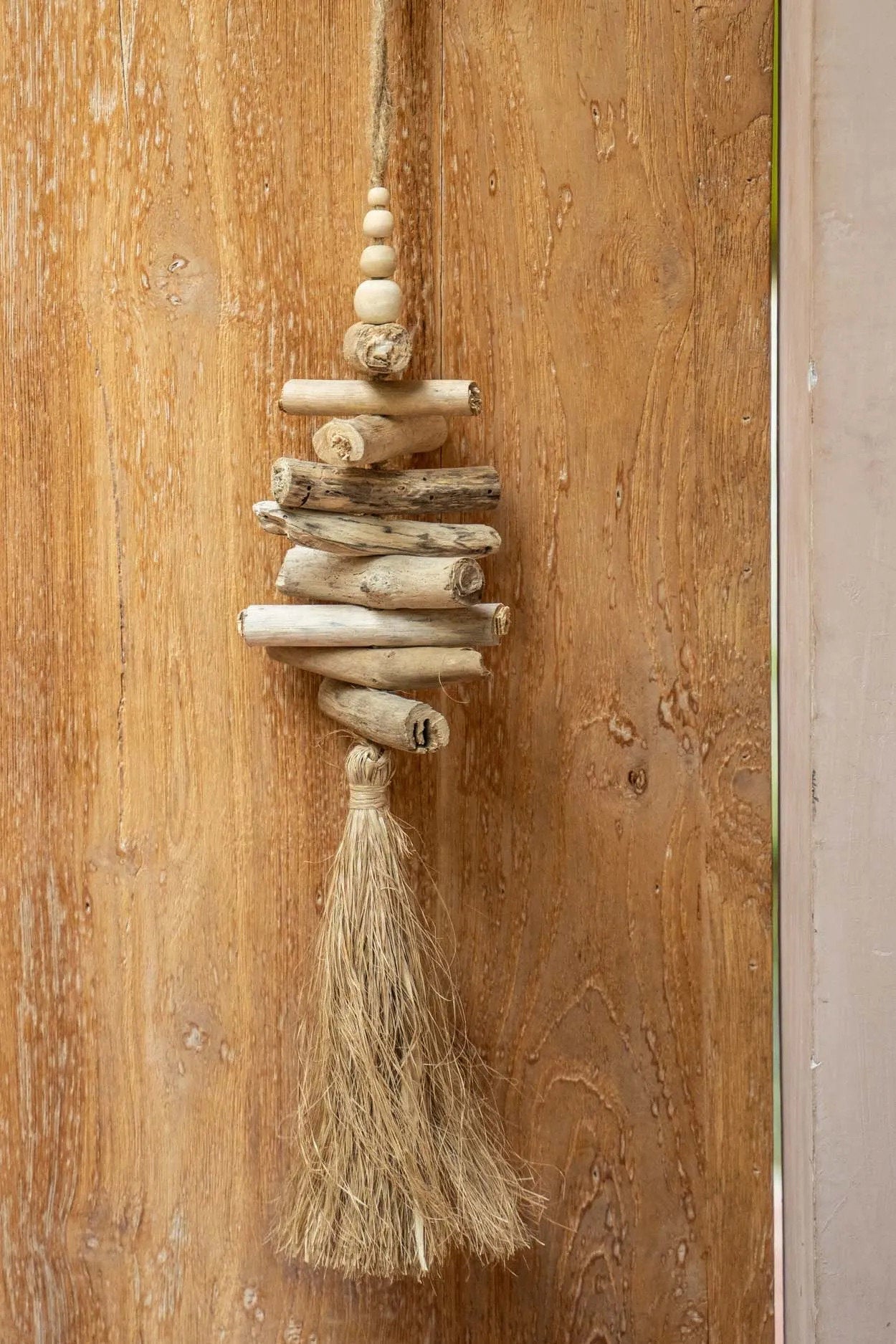 Die hängende Dekoration aus Raffia-Treibholz